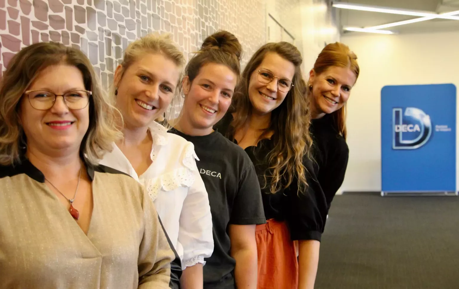 Female DECA colleagues smiling at camera